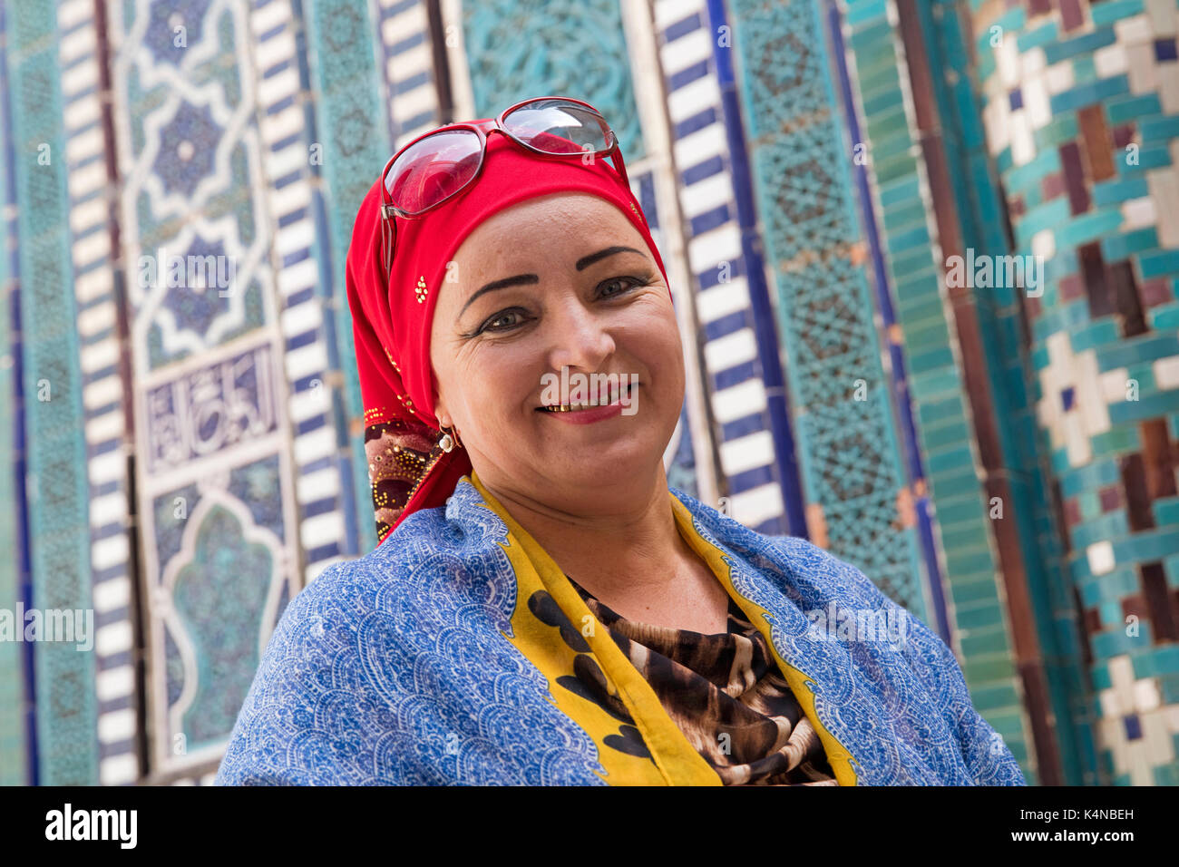 Uzbek musilim woman with gold teeth dressed in traditional dress with red headscarf in Samarkand, Uzbekistan Stock Photo