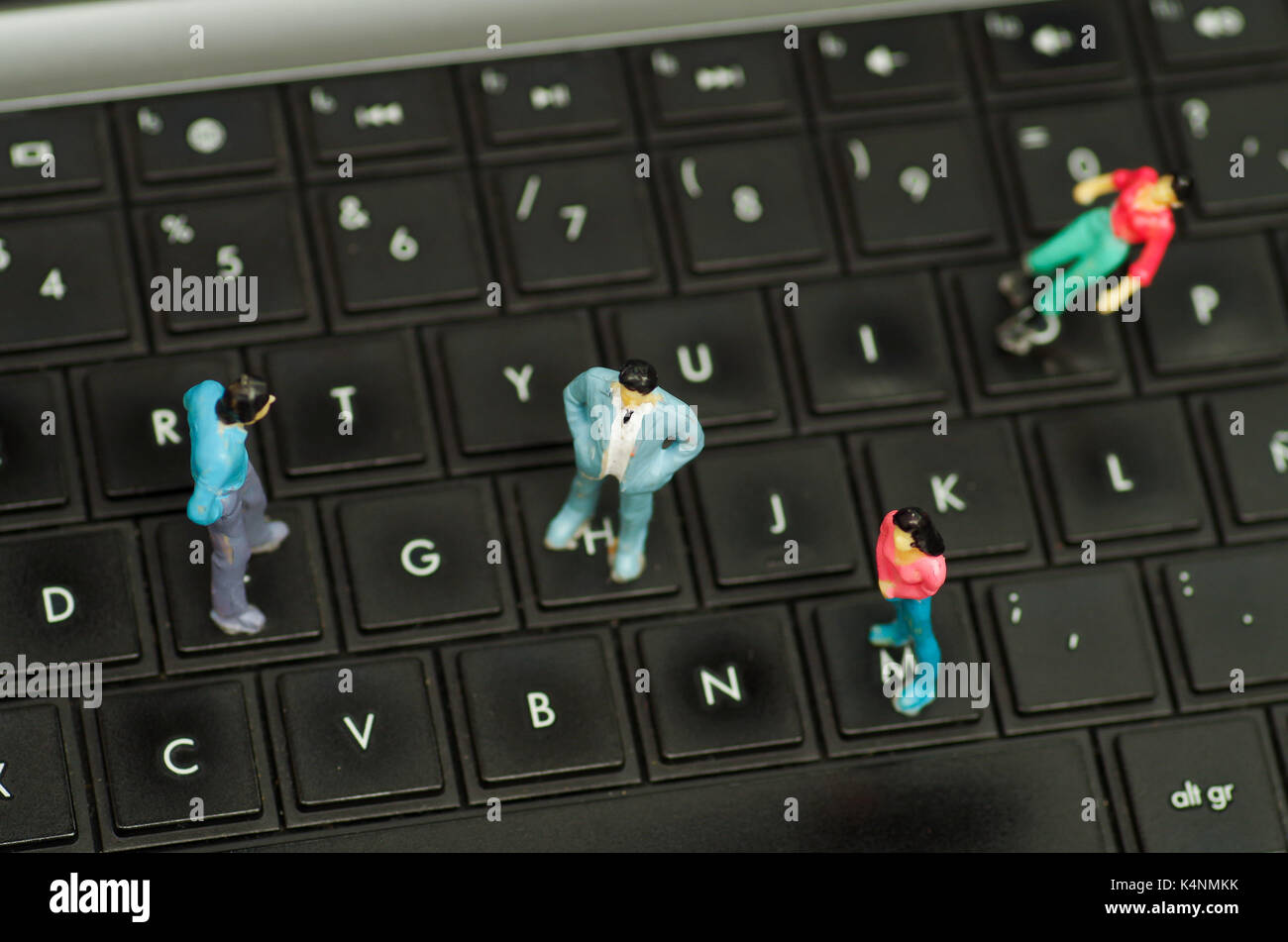 Miniature little people, group of friends over a computer keyboard, in ...