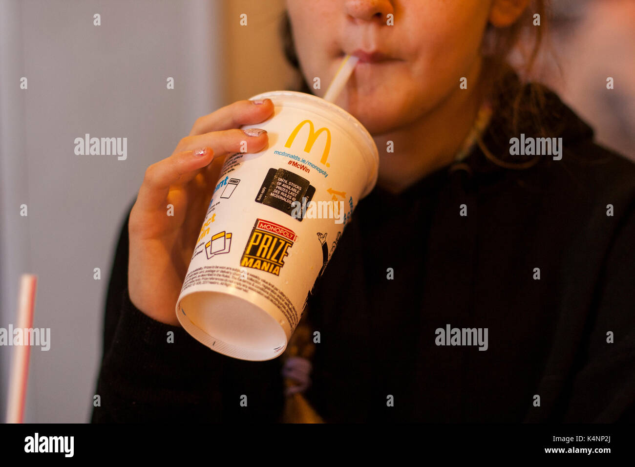 Person drinking from a McDonald's paper cup with a straw, closeup Stock ...