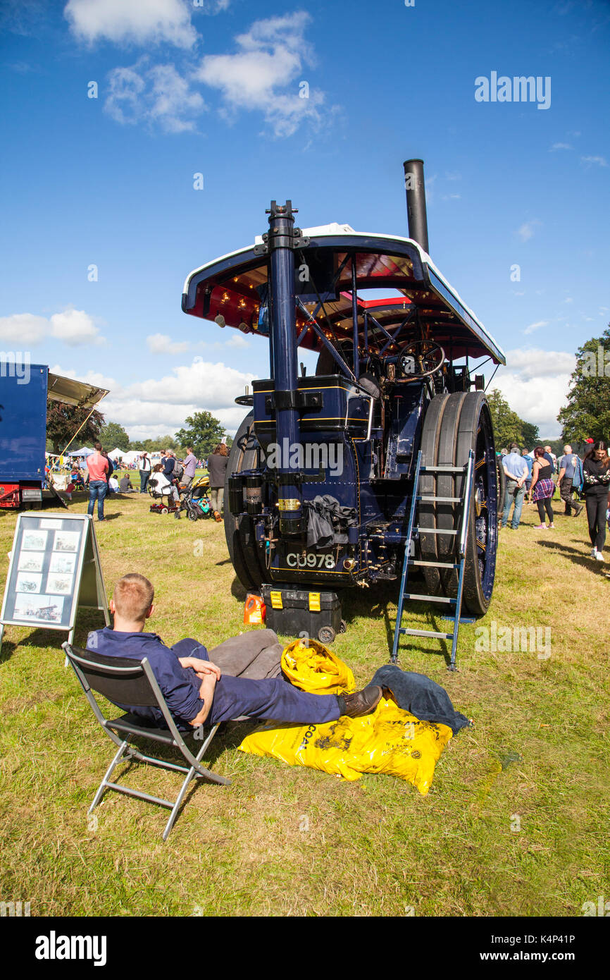 Exhibitor taking a break at the rear of his steam traction engine at the annual steem rally at Astle park Chelford Cheshire Stock Photo