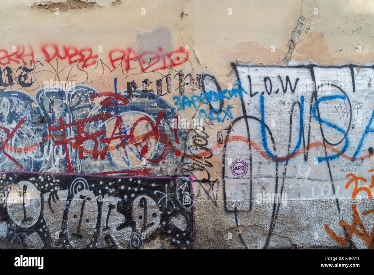 Old vandalised wall full of graffiti, tags, writings and spray paint
