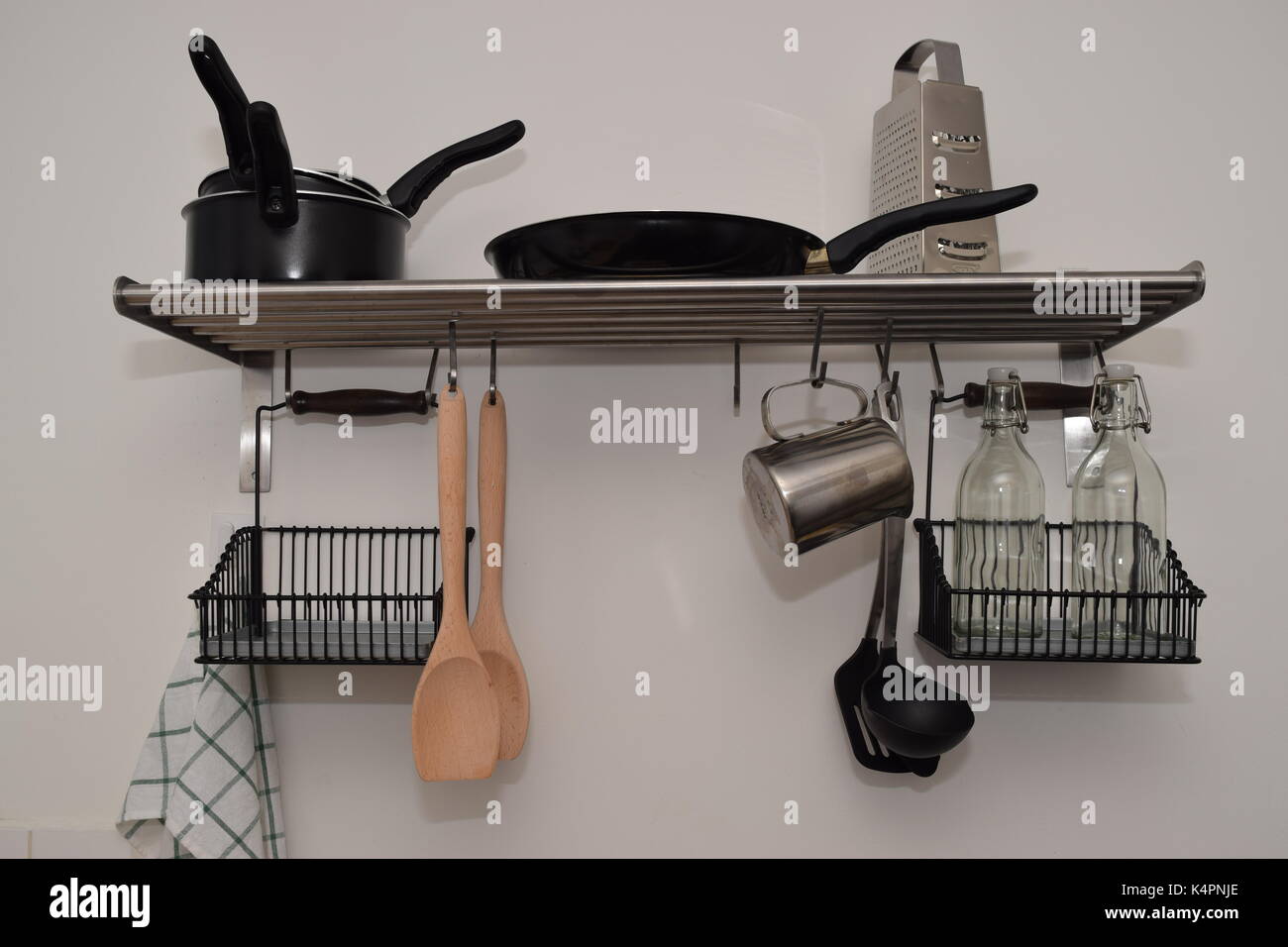 New, clean kitchen utensils hanging on the kitchen wall Stock Photo - Alamy