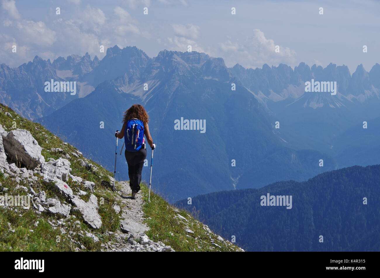 Young femaie trekker hiking on a trail in the Dolomites, Italy, range of Marmarole Stock Photo