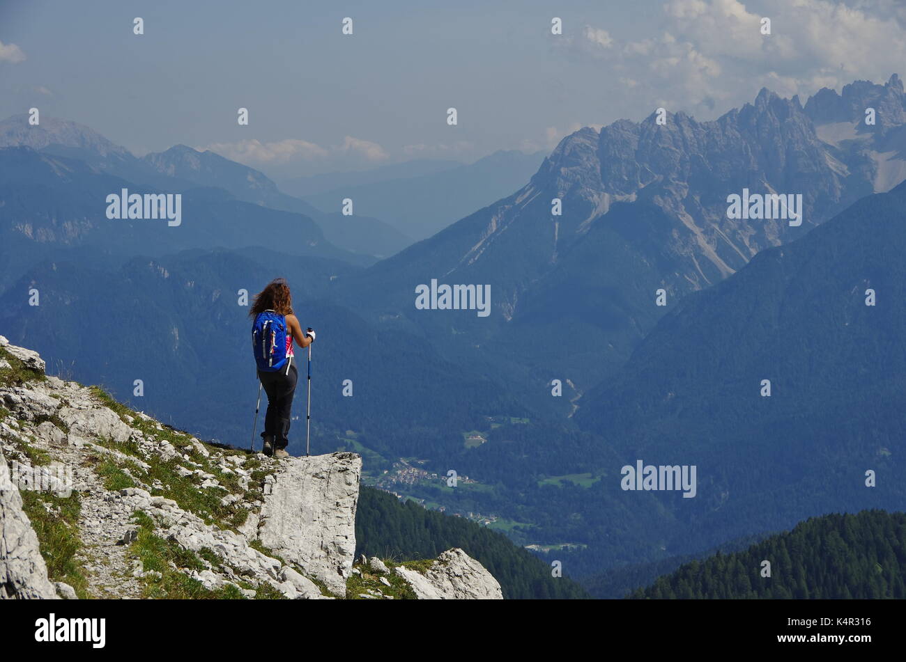 Young femaie trekker hiking on a trail in the Dolomites, Italy, range of Marmarole Stock Photo