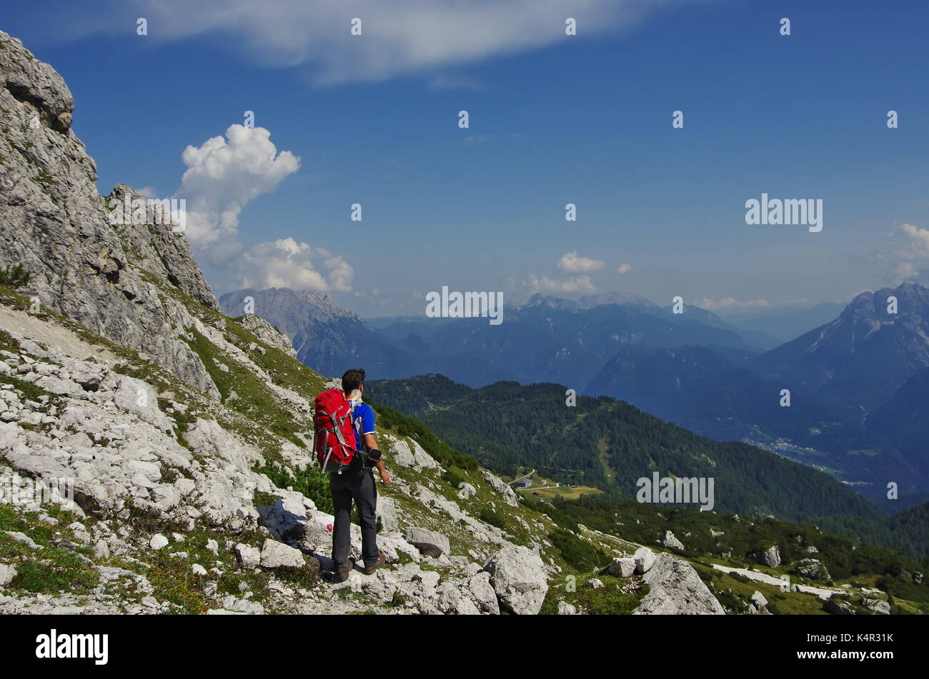 Young maie trekker hiking on a trail in the Dolomites, Italy, range of Marmarole Stock Photo