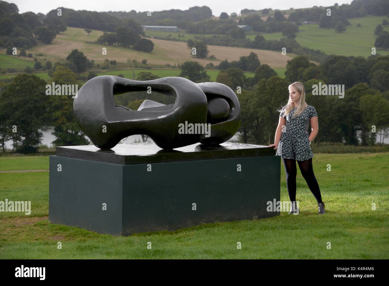 A visitor to Yorkshire Sculpture Park, West Yorkshire, UK, looking at Reclining Connected Forms by Henry Moore. Stock Photo