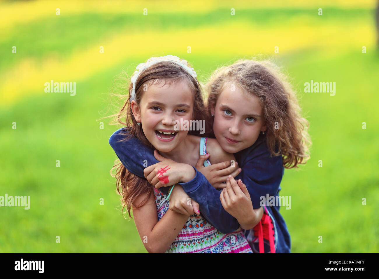 Friendly hugging of two joyful girls Stock Photo