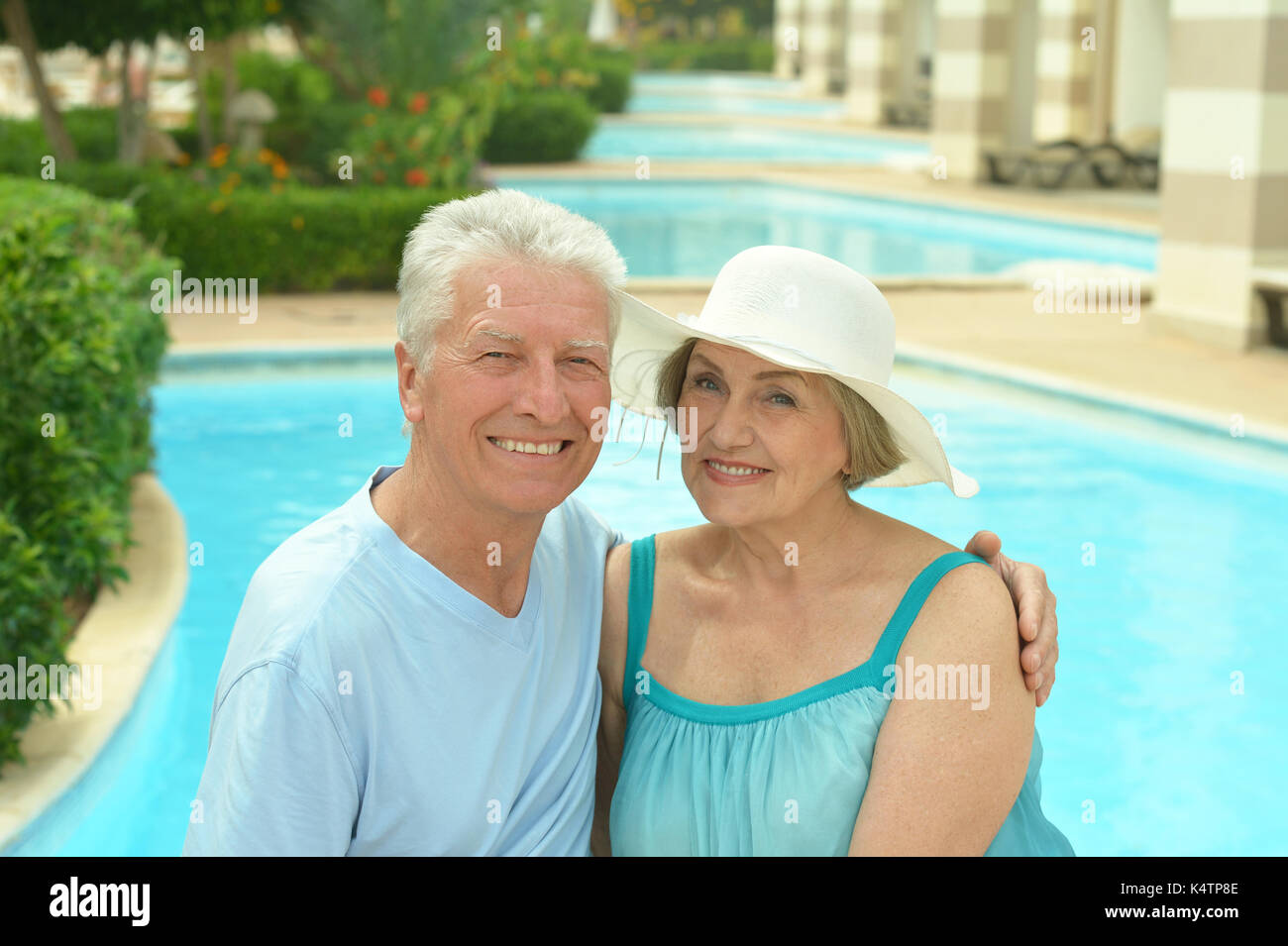 Senior couple relaxing at pool at hotel resort Stock Photo - Alamy