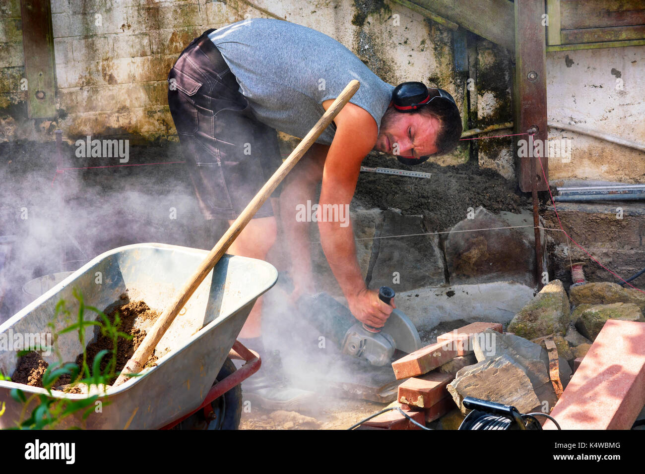 Worker cuts the bricks with a cut-off grinder. Stock Photo