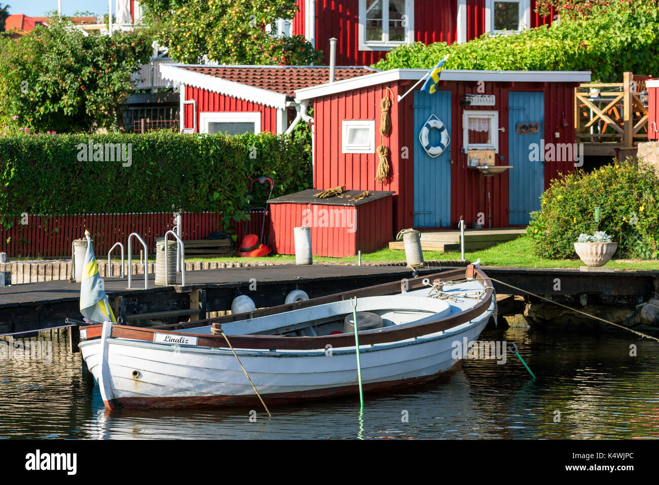 Karlskrona, Sweden - August 28, 2017: Travel documentary of the city surroundings. White open wooden motorboat moored to a pier in front of fishing sh Stock Photo