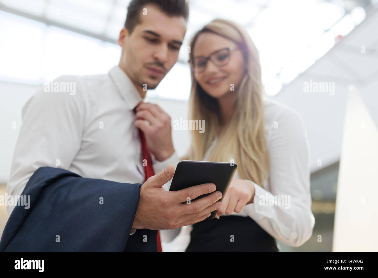 Young successful businesspeople using tablet in office, depth of field Stock Photo