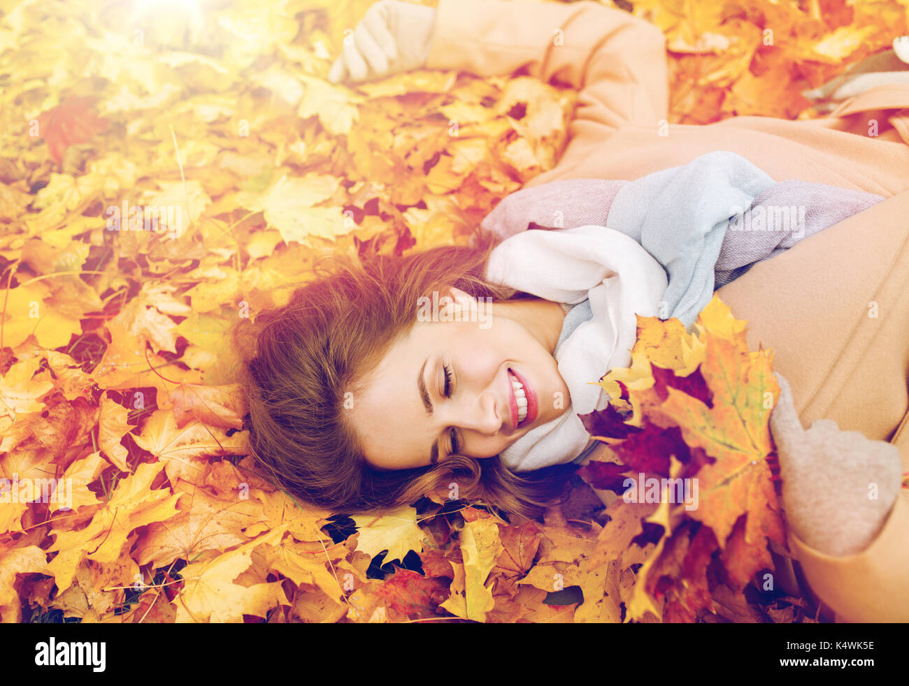 beautiful happy woman lying on autumn leaves Stock Photo - Alamy