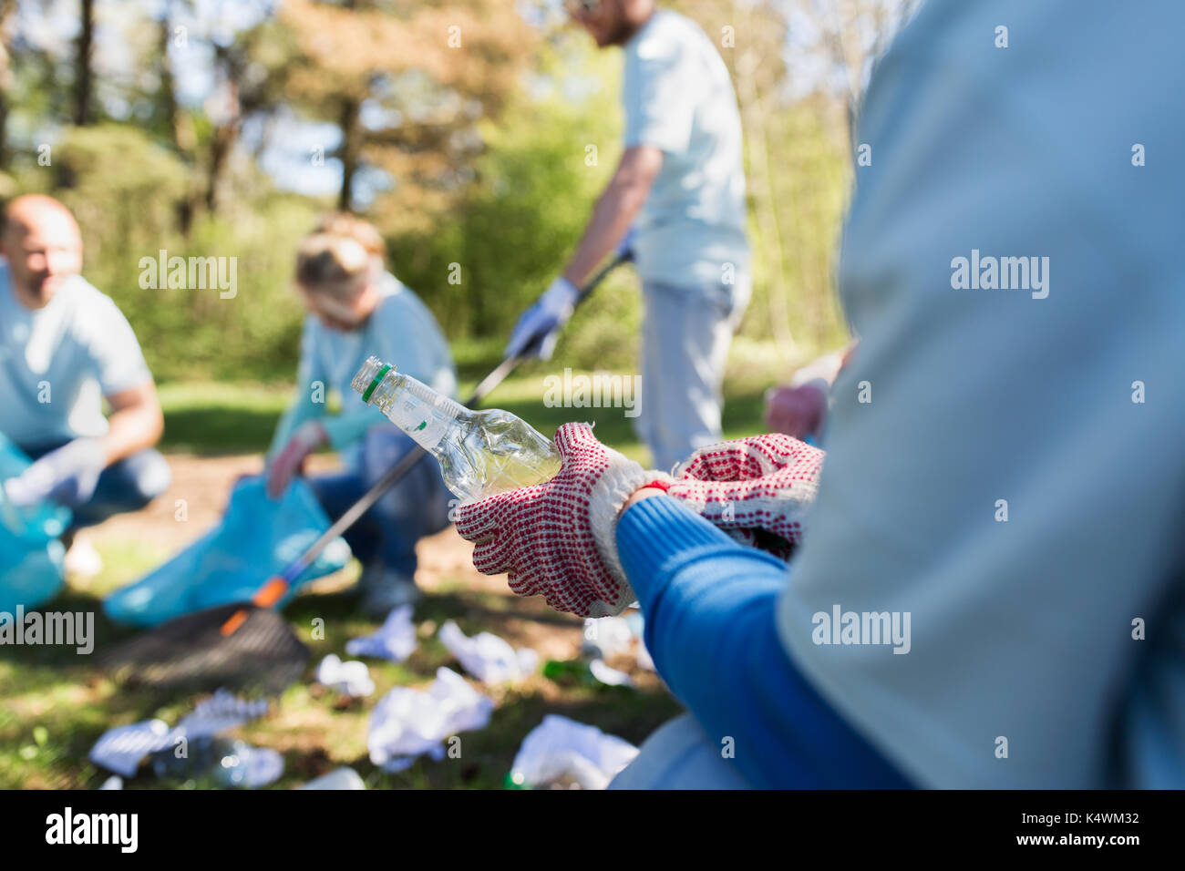 volunteer with trash bag and bottle cleaning area Stock Photo