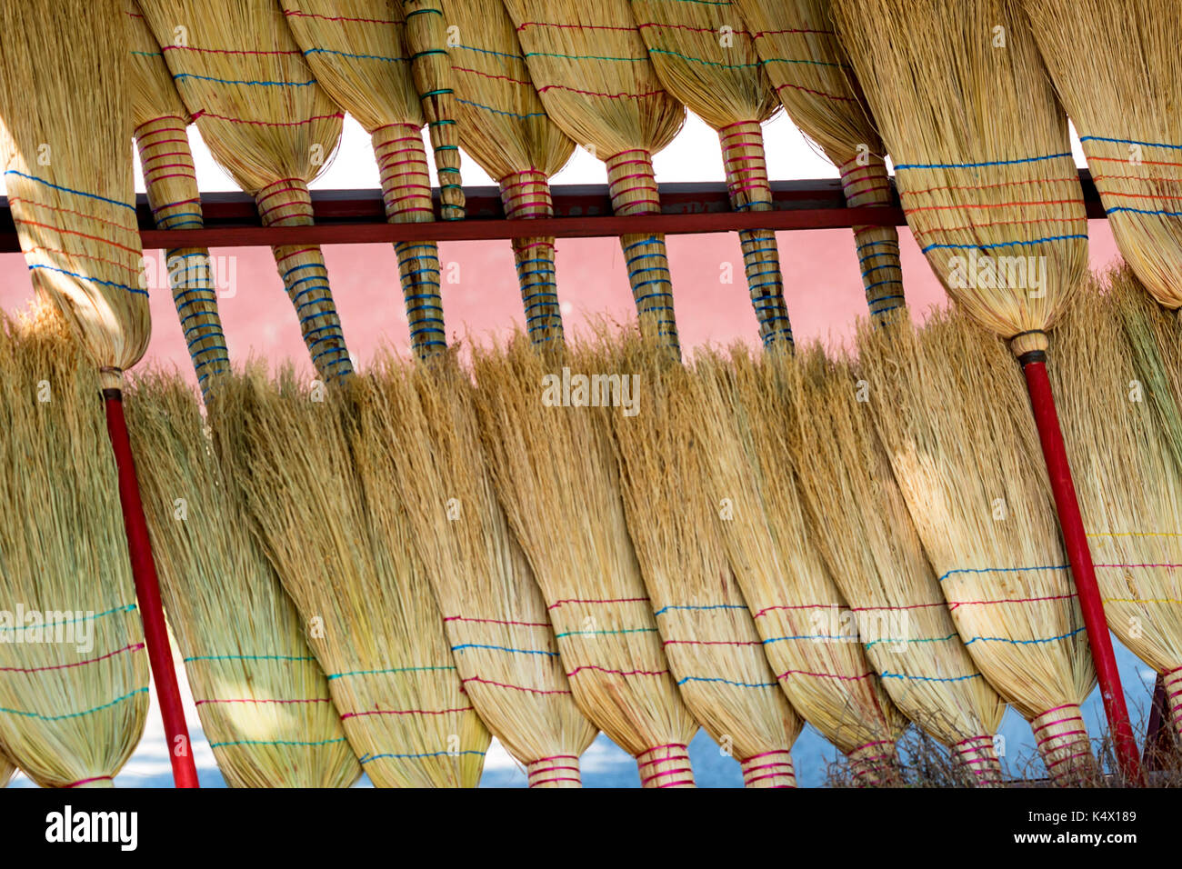 Several new straw brooms on market Stock Photo