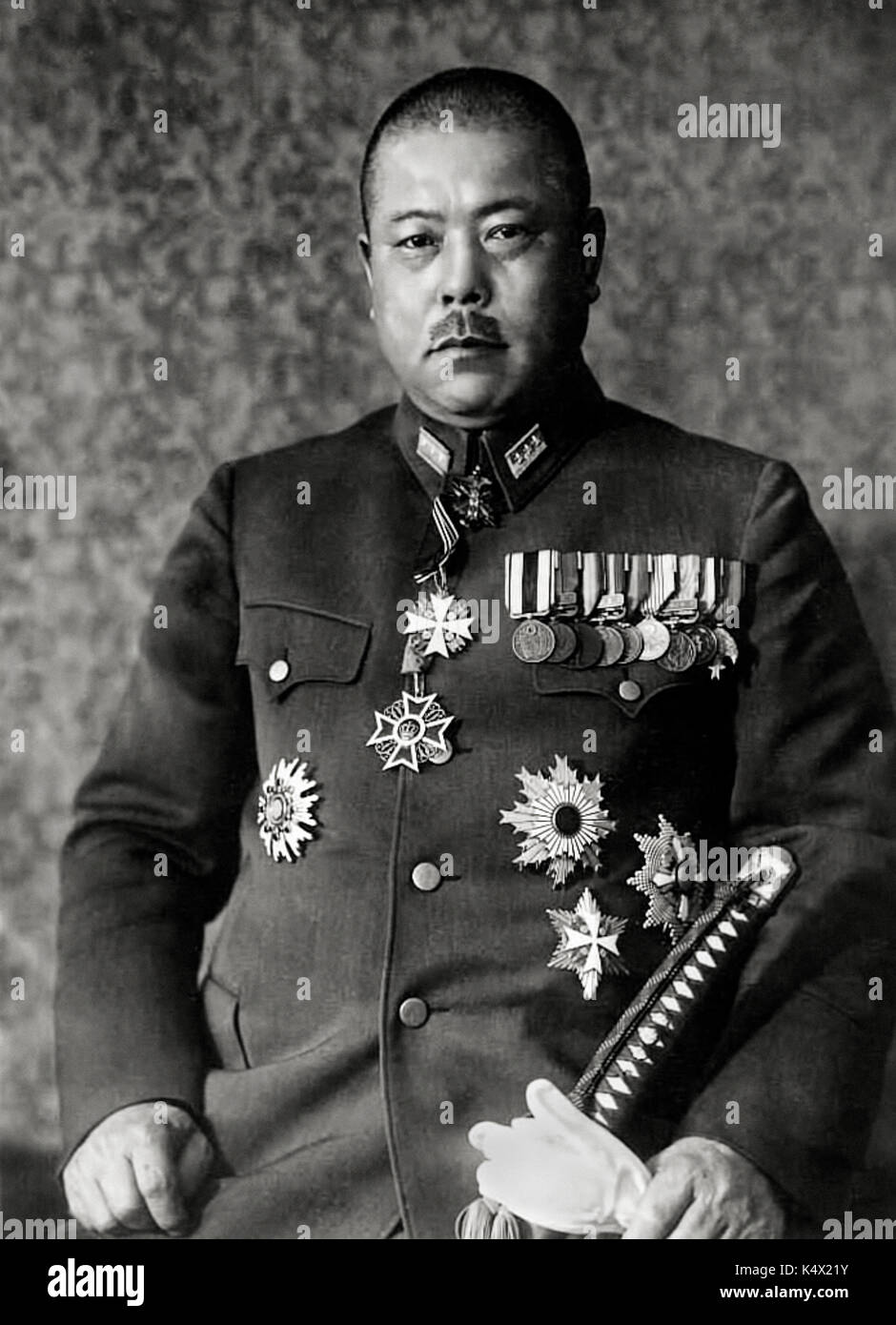 General Tomoyuki Yamashita (1885-1946) highly decorated commander of the Japanese 25th Army nicknamed the “Tiger of Malaya”. Studio photograph circa 1942 with medals and samurai sword. Stock Photo