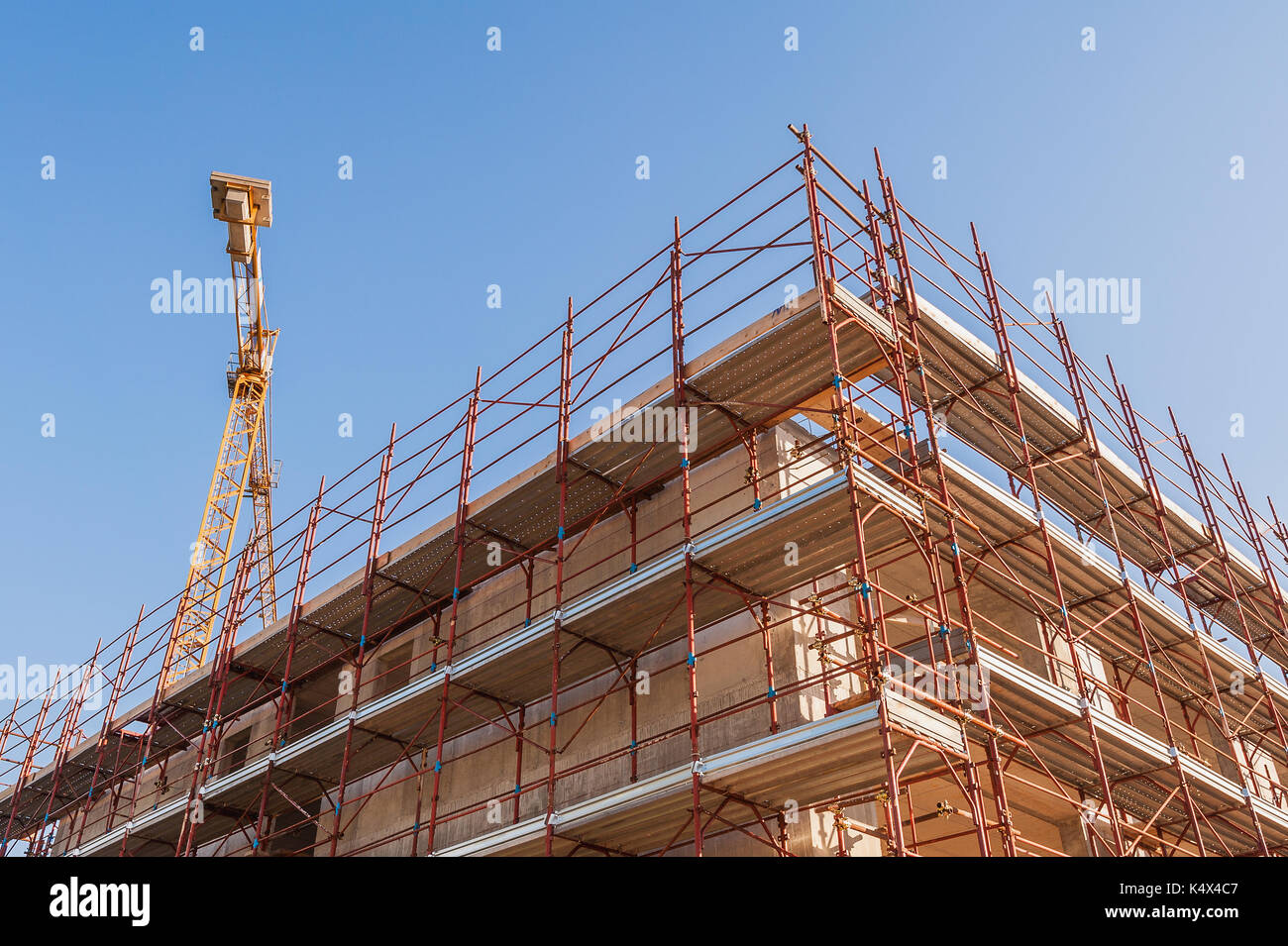 House under construction with scaffolding and construction crane Stock