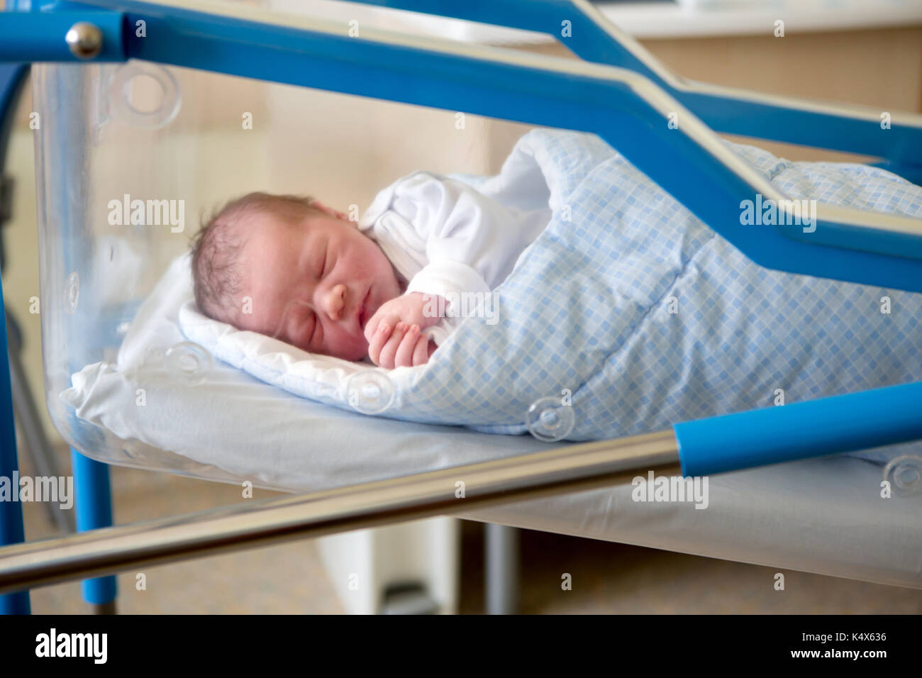 Beautiful newborn baby boy, laying in crib in prenatal hospital Stock Photo