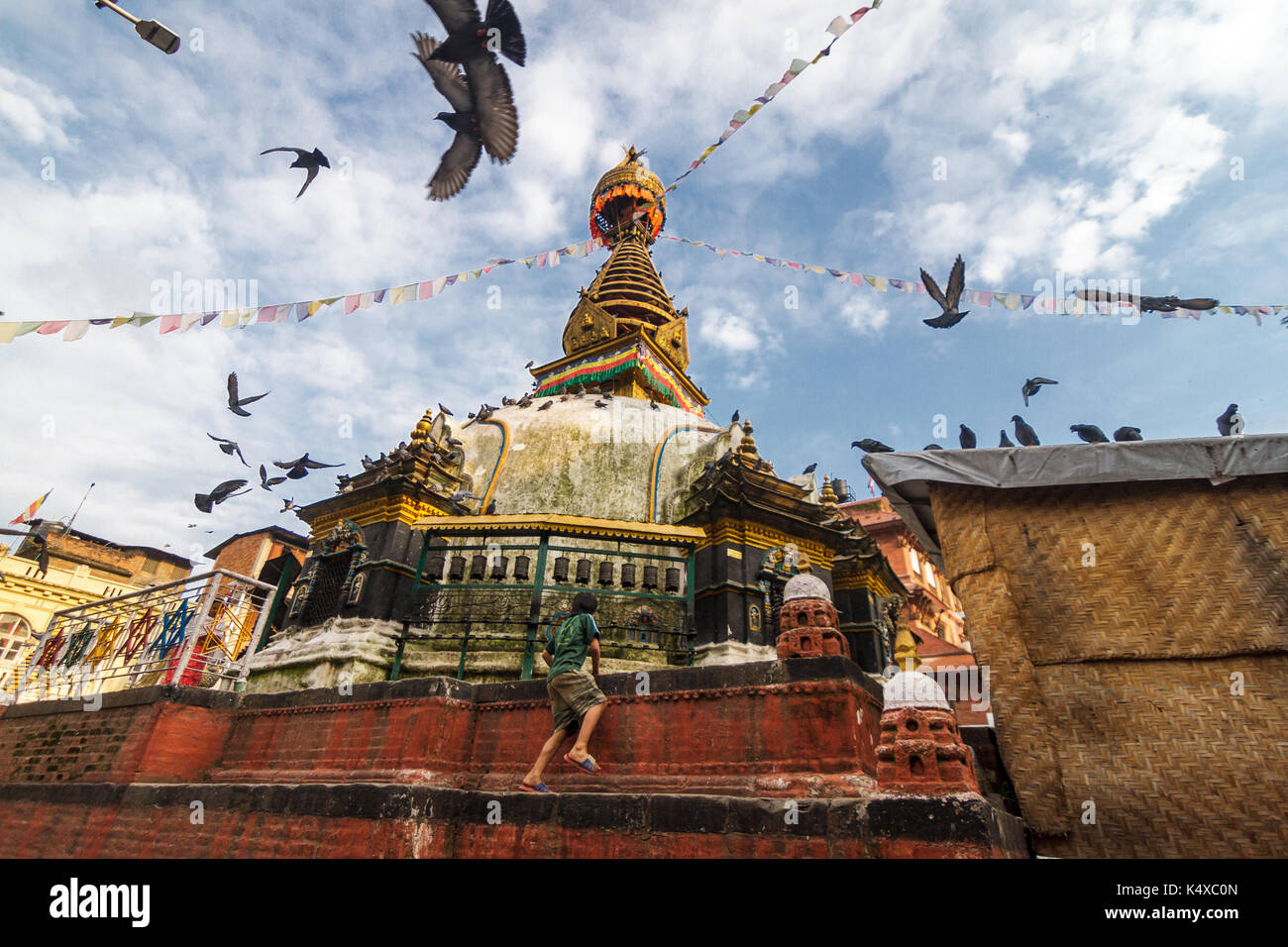 A young boy climbs up the Kathesimbhu Shree Gha Stupa in Kathmandu, Nepal. Stock Photo