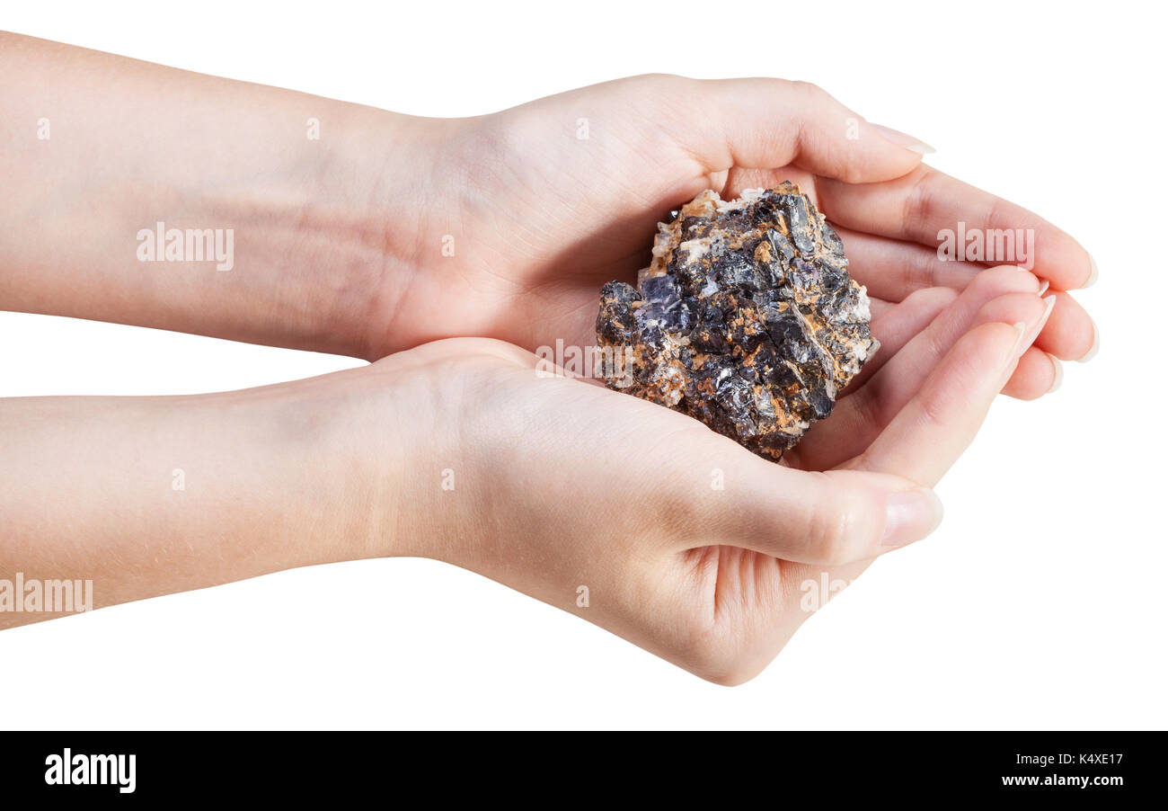 side view of zinc and lead mineral ore (sphalerite with galena) in handful isolated on white background Stock Photo