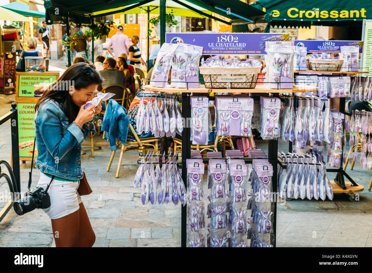 Attractive brunette woman (30-35) smelling lavender for sale in Grasse, Cote d'Azur, France. The city is famous for its perfumes Stock Photo