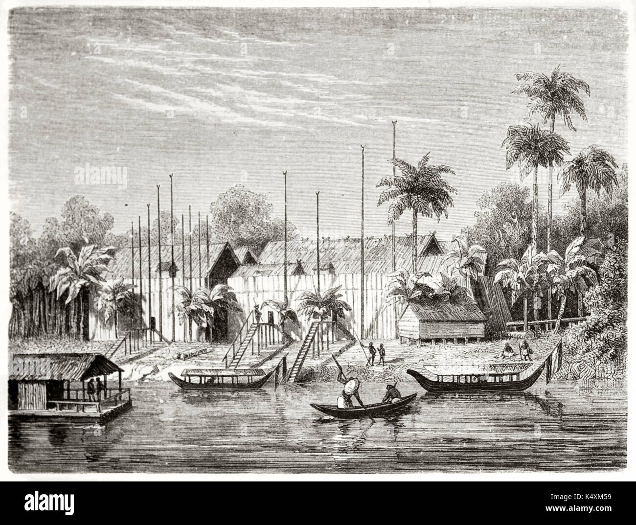 Ancient river in the jungle flowing near to a native Dayak people village, Borneo. Boats sailing and palms on background. Created by Francais after Schwaner published on Le Tour du Monde Paris 1862 Stock Photo