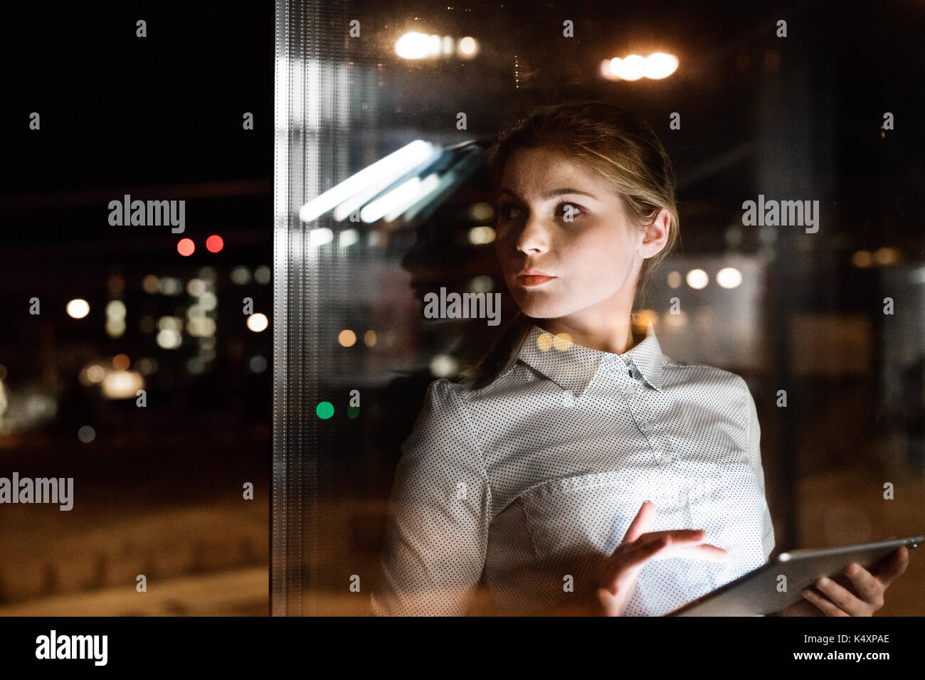 Businesswoman with tablet working late at night. Stock Photo