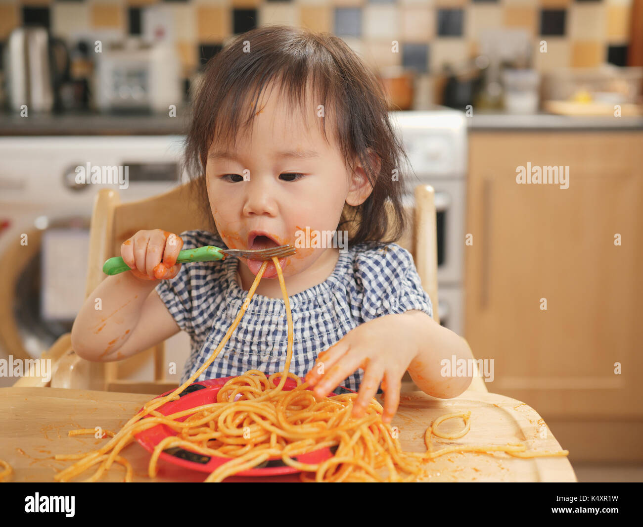 baby girl eating messy spaghetti at home Stock Photo Alamy