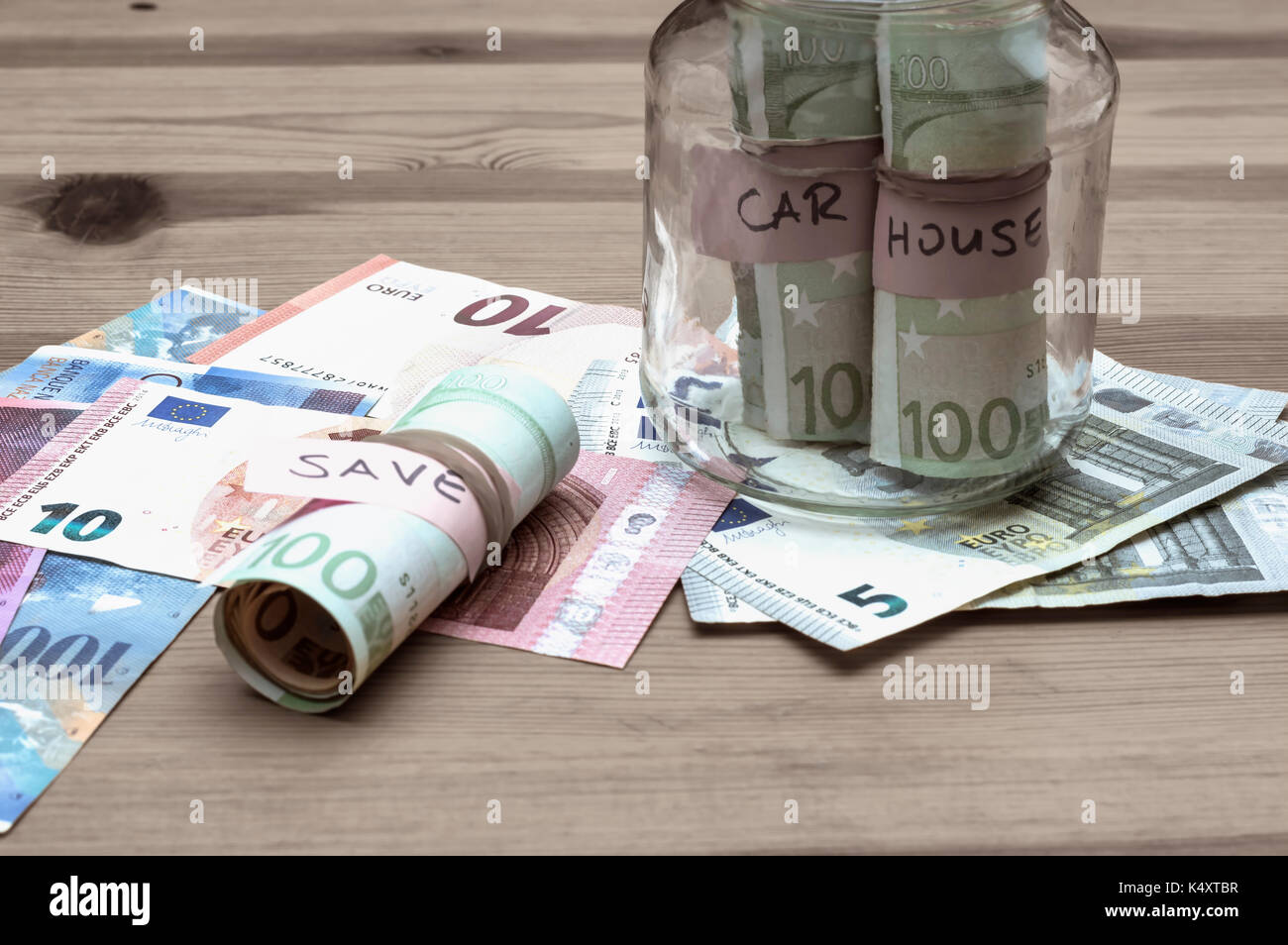 Saving money for house and car concept. Stack of several euro banknotes on table. Stock Photo