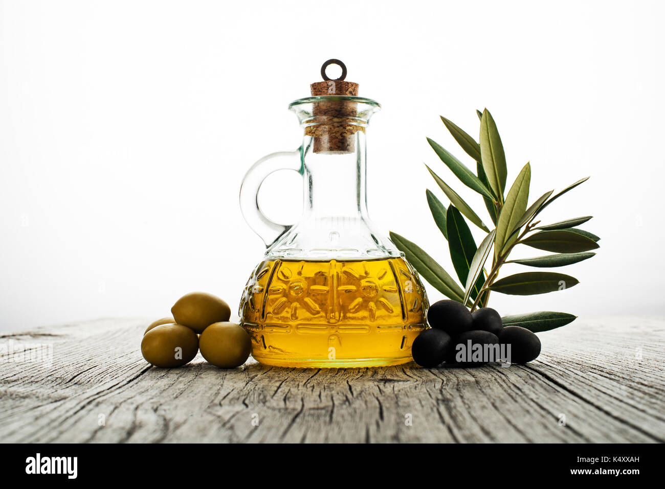 Olive oil and olive branch on wooden table Stock Photo - Alamy