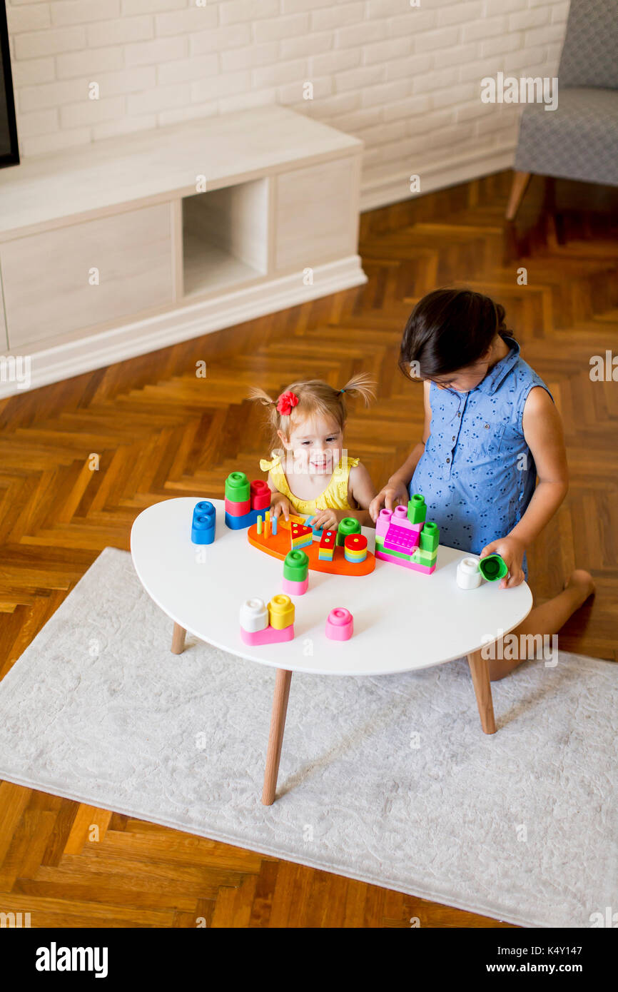 Two little girls playing with toys in the room at home Stock Photo - Alamy