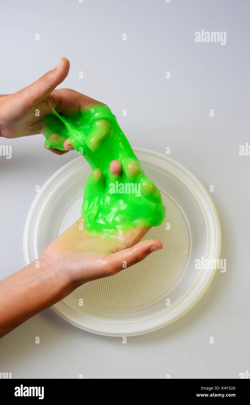 Slime, green pate elastic and vicous on child's hand Stock Photo