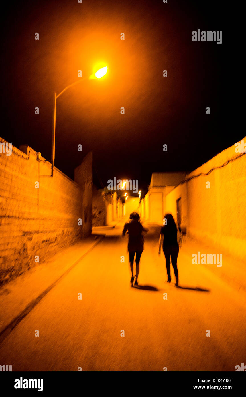 Two girls walking down a lonesome street by night, La Solana, Spain Stock  Photo - Alamy