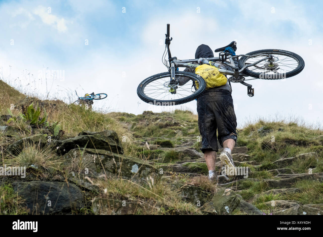 Mountain biker. Cyclist carrying a mountain bike up a hill. Jacob's