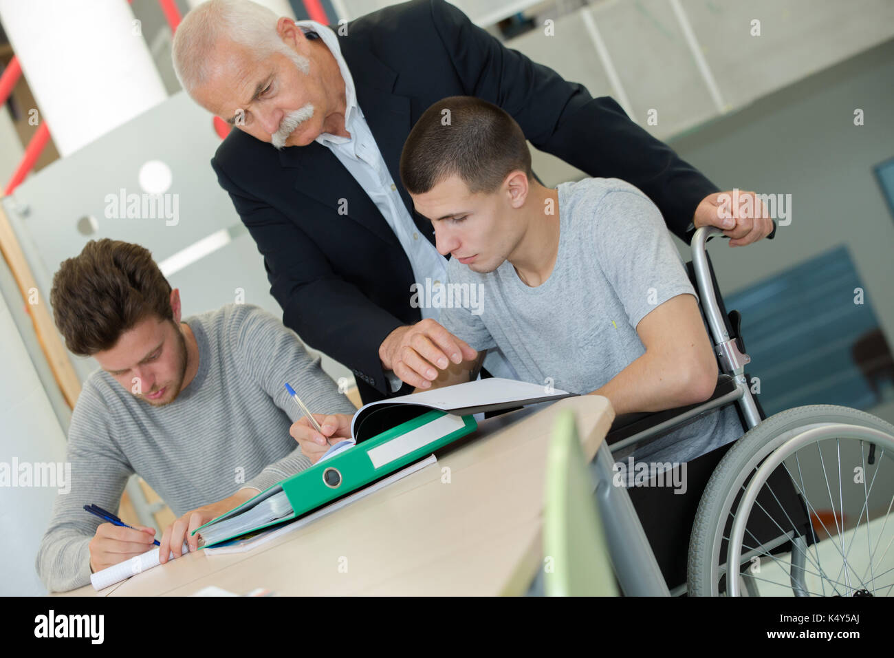 student in wheelchair working in assitance class Stock Photo