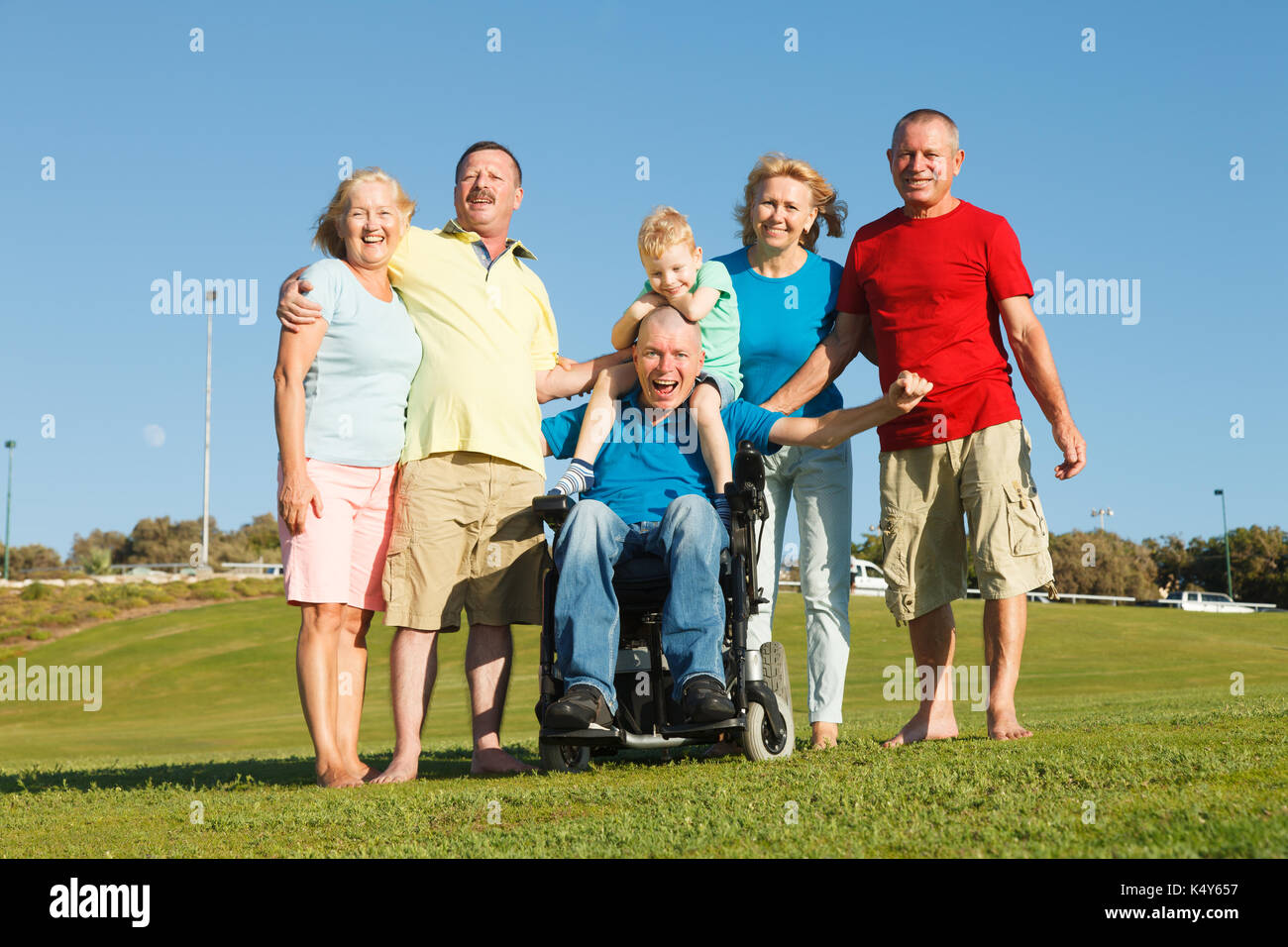 Disabled man with family outside showing unity. Stock Photo