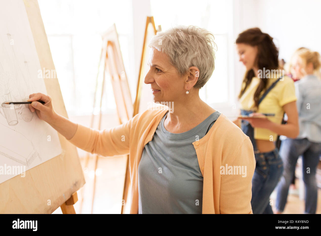 woman artist with easel painting at art studio Stock Photo by dolgachov