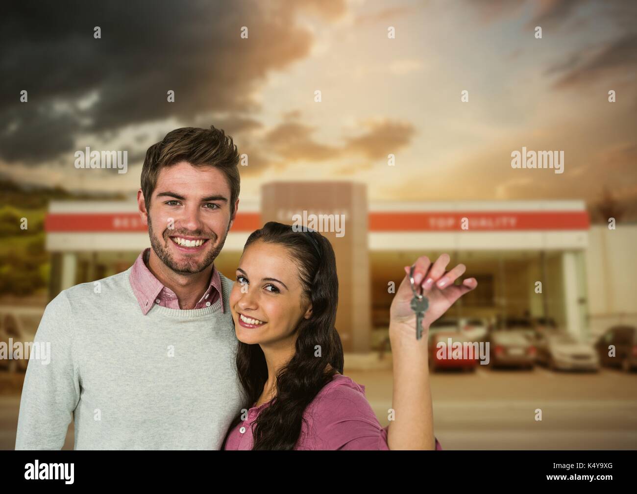 Digital composite of Couple  Holding key in front of cars Stock Photo