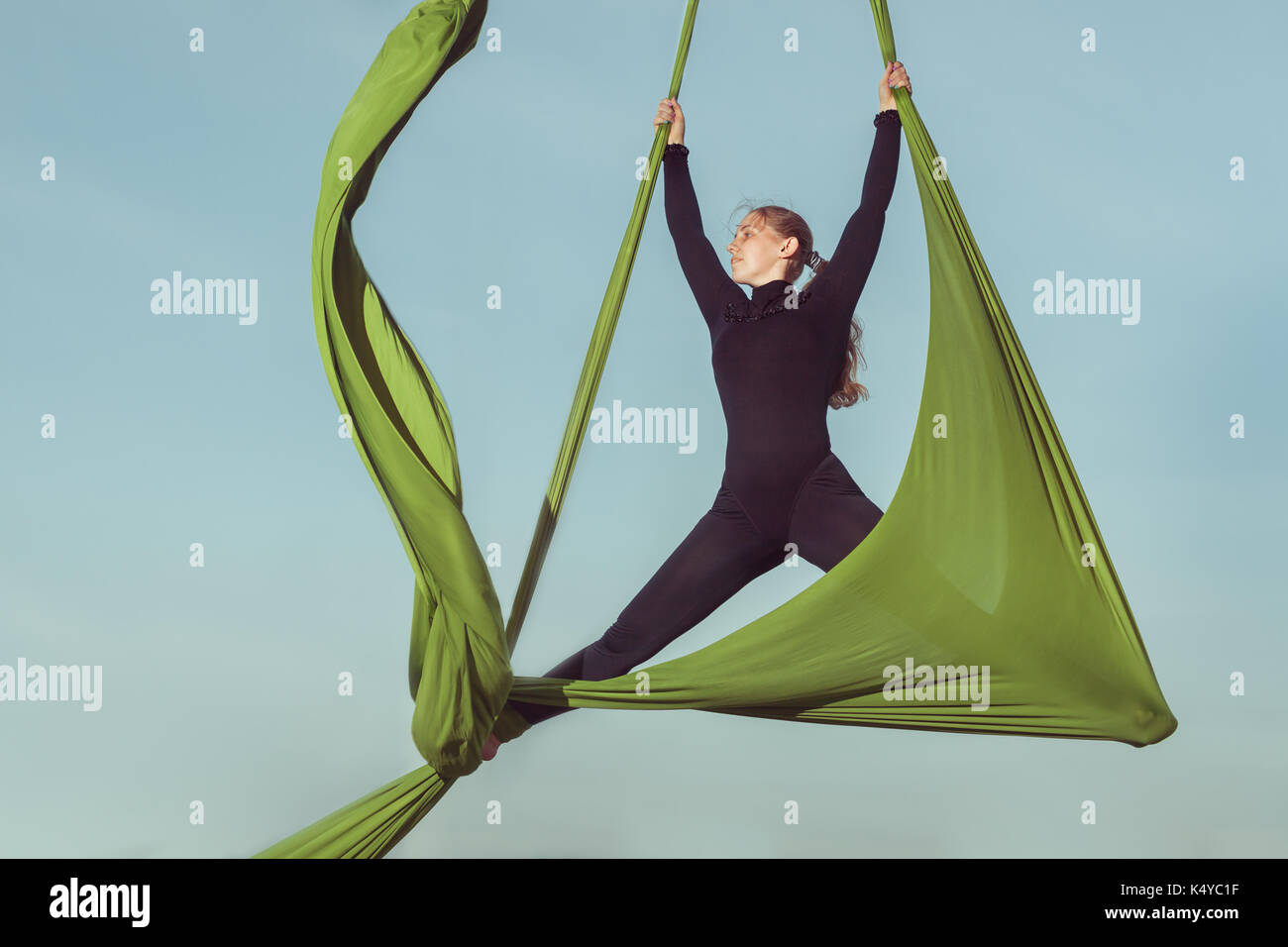 Sporting tricks on a hammock, woman aerial acrobat. Stock Photo