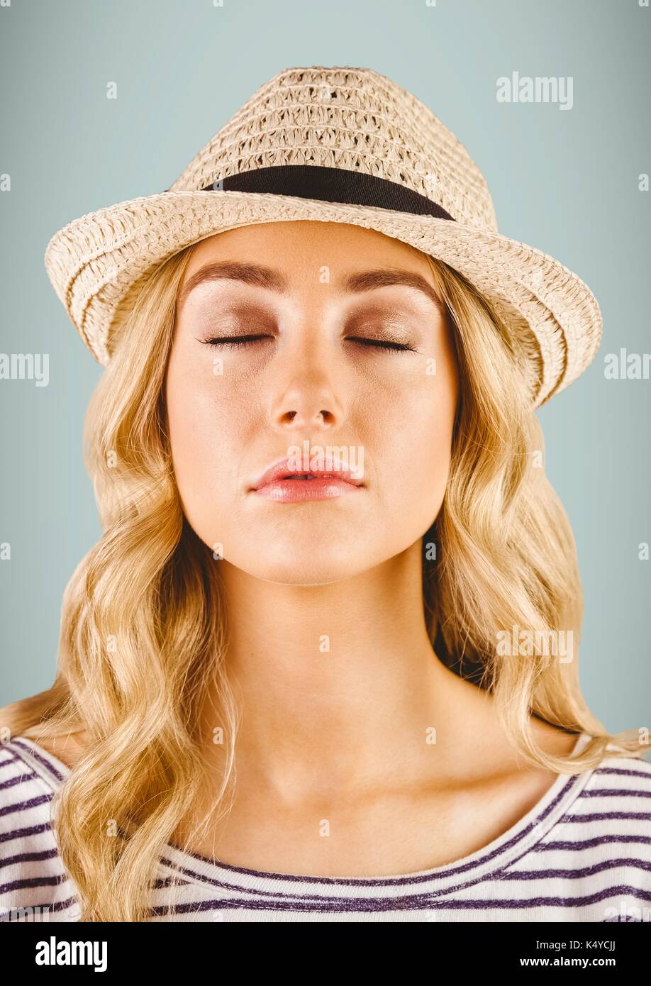 Digital composite of Close up of millennial woman with eyes closed against grey background Stock Photo