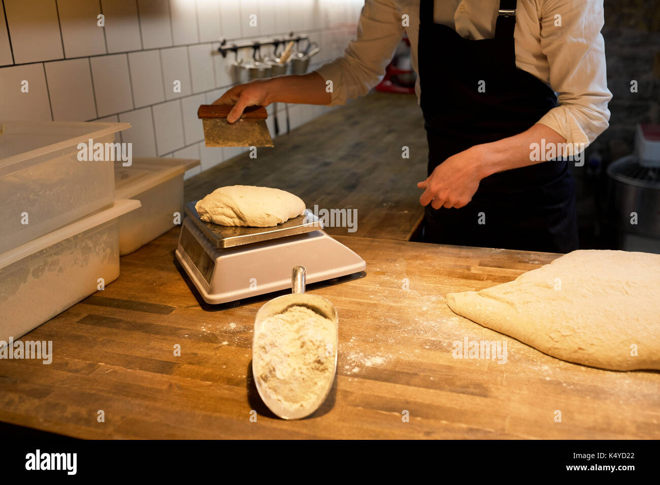baker weighing bread dough on scale at bakery Stock Photo - Alamy