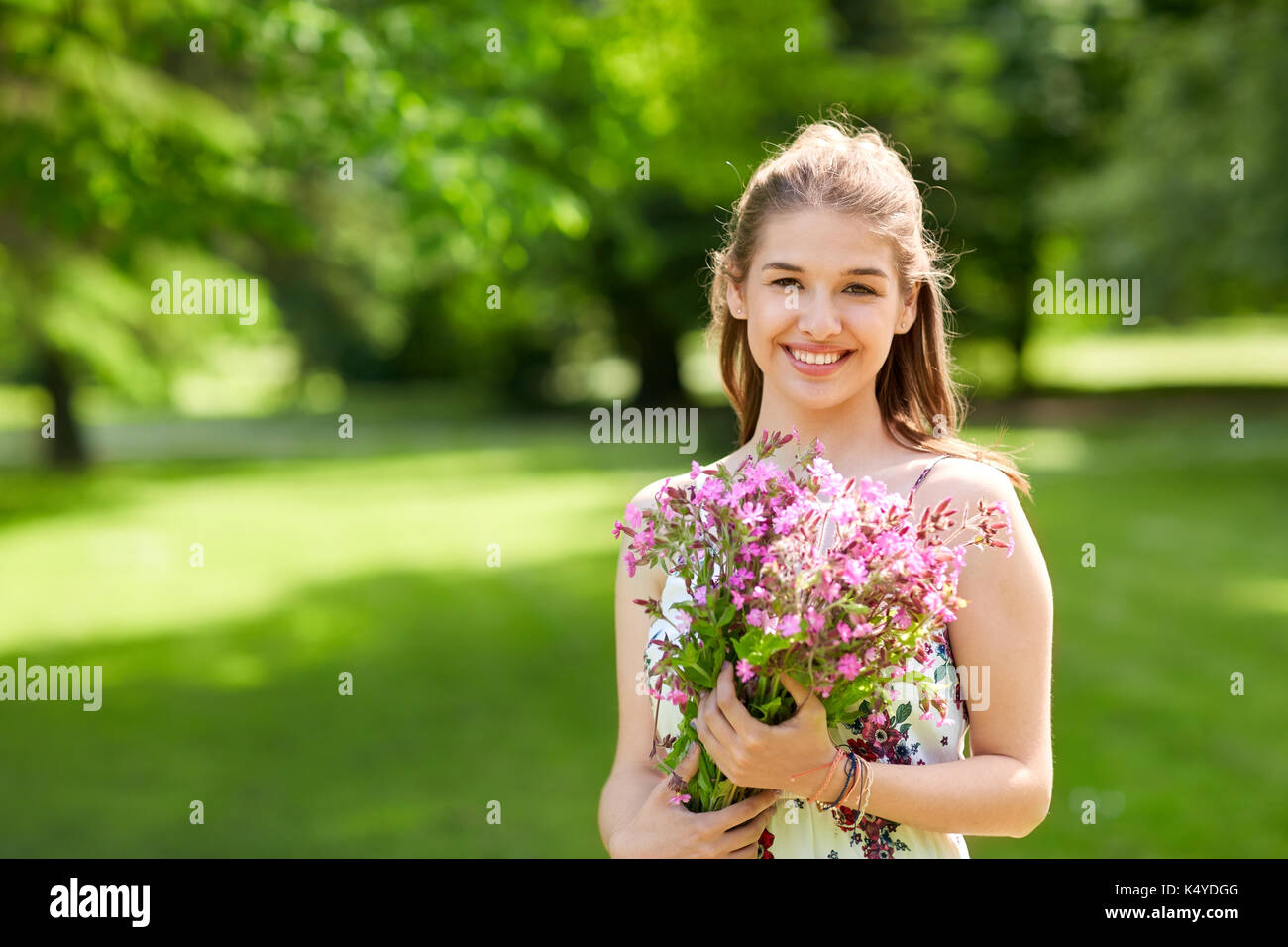 happy young woman with flowers in summer park Stock Photo - Alamy