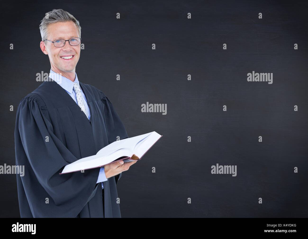 Digital composite of Male judge with open book against navy chalkboard ...