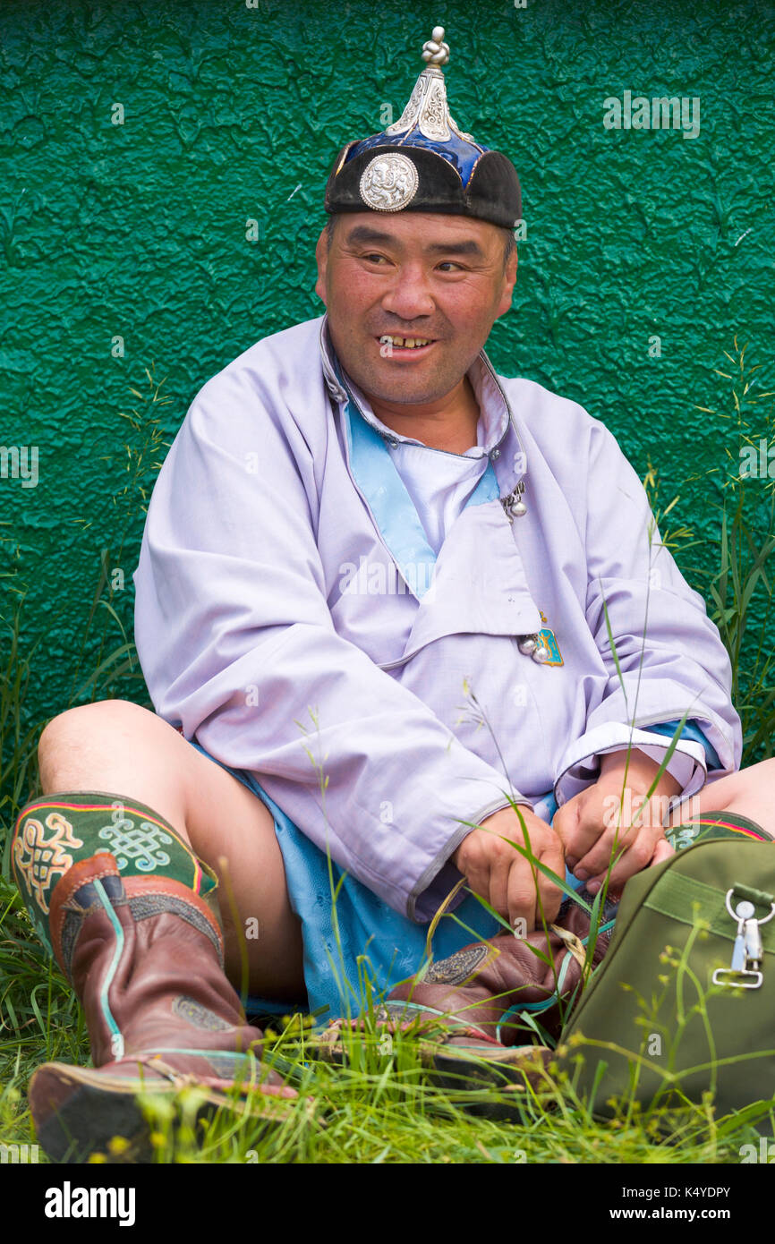 Ulaanbaatar, Mongolia - June 11, 2007: Heavyweight wrestler smiling and sitting on grass rests before his match at the Naadam Festival wrestling event Stock Photo