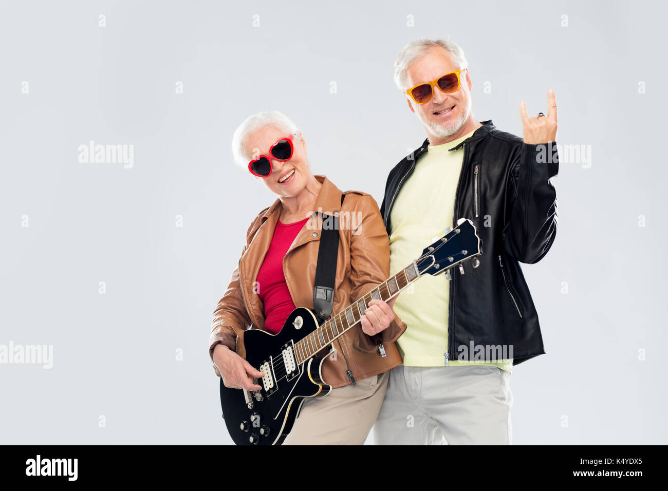 senior couple with guitar showing rock hand sign Stock Photo