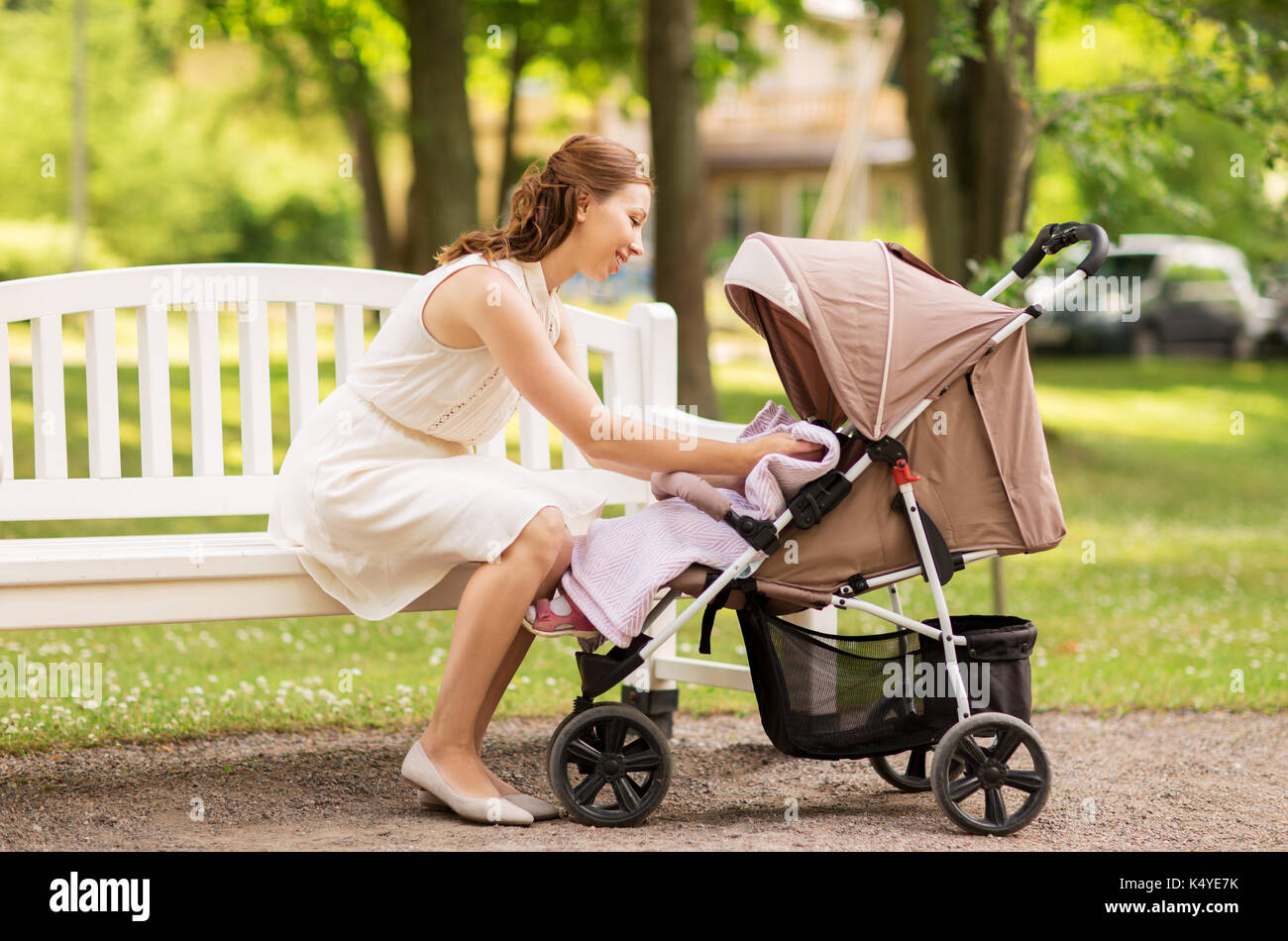 happy mother with child in stroller at summer park Stock Photo