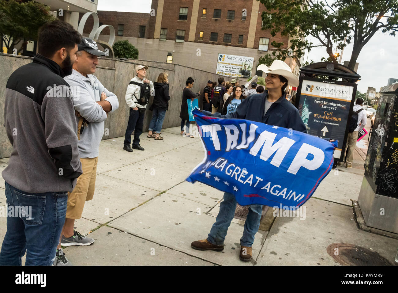 Newark, United States. 6th September, 2017. A Donald Trump supporter waves his flag in support of the removal of DACA as the crowd jeers at his display. DACA is an Obama era legislation that allows those who immigrated as children to remain in the USA on a special visa. Almost 800,000 people are under threat of deportation. Most of those threatened with deportation are students who have been living inside the country for years. Mack William Regan/Alamy Live News Stock Photo