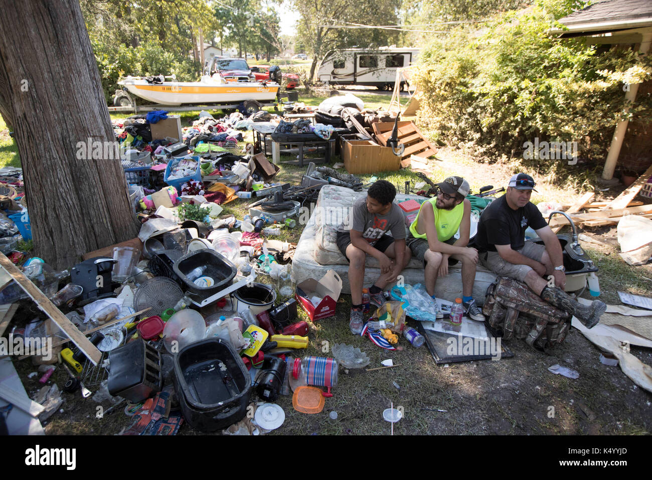 USA. 07th Sep, 2017. Baytown, Texas USA Sept. 7, 2017: Eric Grafton, Brandon Hawley and Shawn Curry sit in front of a house at 307 Bayou Bend in Baytown as they continue to clean their house of all household items in an attempt to dry it out after Hurricane Harvey almost two weeks ago. Credit: Bob Daemmrich/Alamy Live News Stock Photo