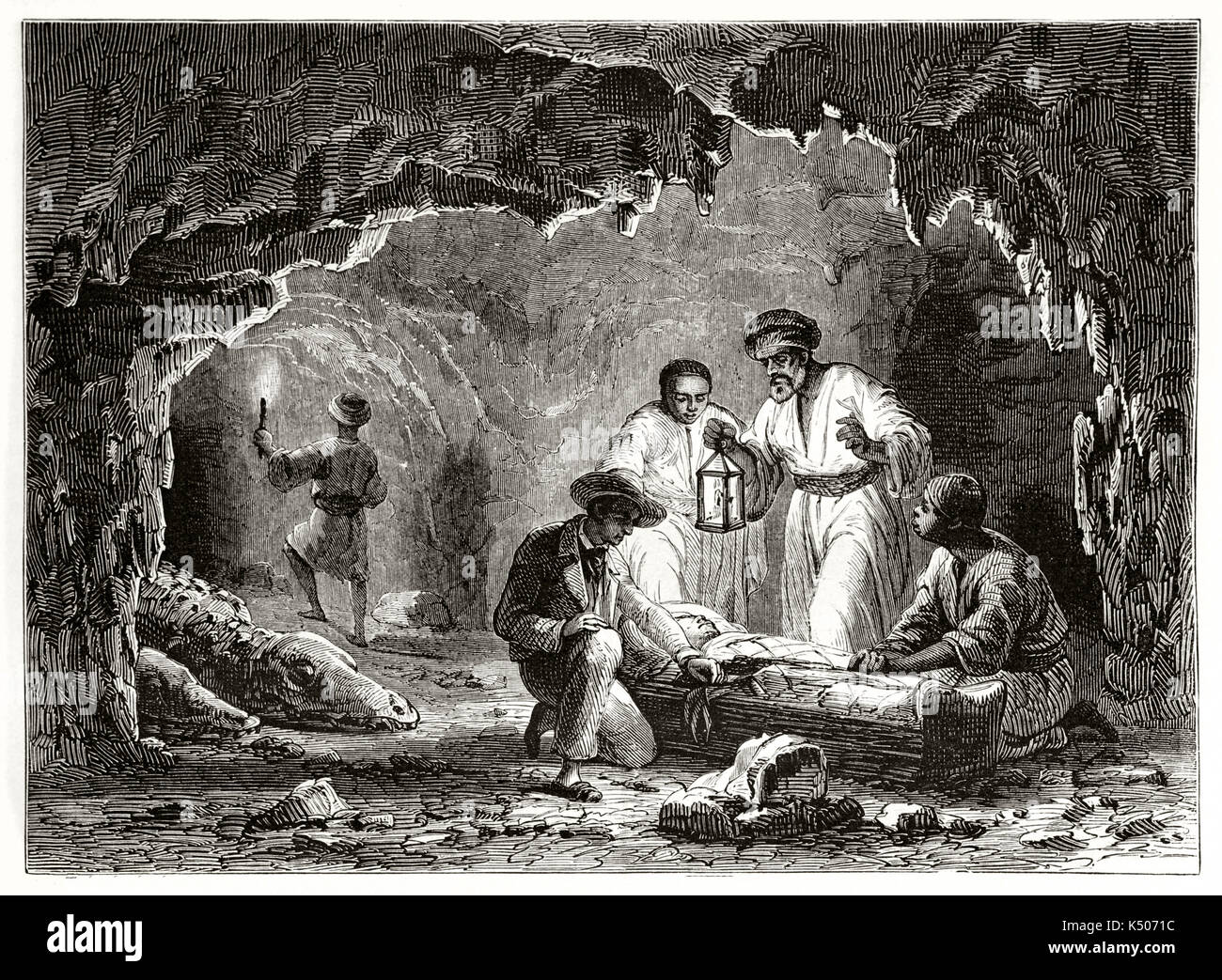 Ancient explorators in a cave finding a mummy in a coffin. Samoun grotto or Crocodile grotto interior Egypt. Created by Girardet after Georges published on Le Tour du Monde Paris 1862 Stock Photo