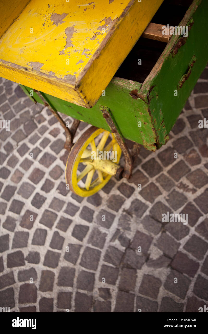 Old wooden wheelbarrow on paved ground in a square Stock Photo