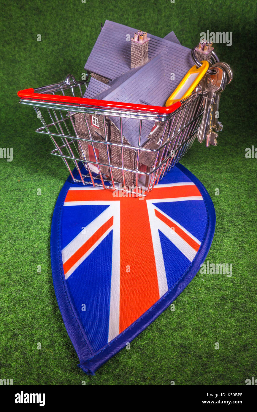 Model house in a model shopping basket, with house keys, on Union Jack colours. A concept to depict the UK housing market of home buying or renting. Stock Photo